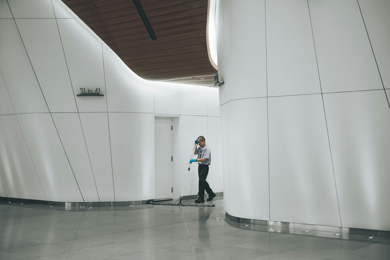 A cleaner mopping a gleaming commercial lobby floor to a spotless finish